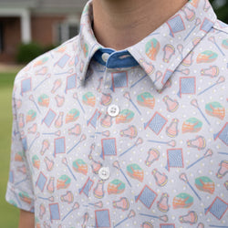 Close up of a person wearing a lacrosse patterned polo shirt.