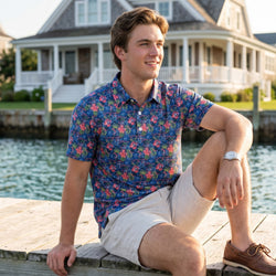 Person wearing a tropical themed polo shirt with lacrosse pattern design on a pier.