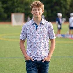 Person wearing a patriotic themed polo shirt with lacrosse pattern design.
