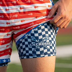 Person wearing red, white, and blue lacrosse-themed shorts with a checkered pattern and 'Lacrosse' text.