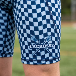 Blue and white checkered shorts with lacrosse design on a grassy field background