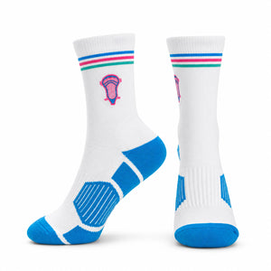 A pair of white crew socks with blue, pink, and green striped cuffs, featuring a pink and blue lacrosse graphic on the side and blue textured panels on the sole and toe.