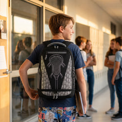 A boy wearing a black and gray patterned lacrosse backpack stands in a school hallway, looking to the side. Other students are visible in the blurred background.
