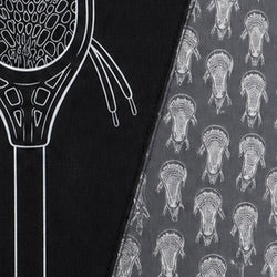 Close-up of a Lacrosse-themed fabric product, showing a black side with a white lacrosse head outline and a gray side with a repeating white lacrosse head pattern.