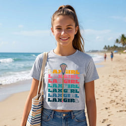 Woman wearing a 'LAX GIRL' crop t-shirt on a beach