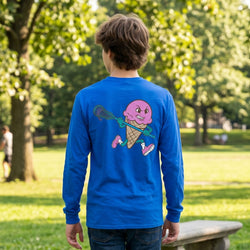 Person wearing a blue long-sleeve shirt with a colorful graphic in a park