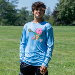 Person wearing a blue long-sleeve shirt with a colorful ice cream lacrosse graphic on a grassy field