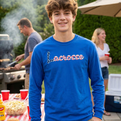Young man wearing a blue 'Lacrosse' shirt at a casual outdoor gathering.