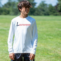 Person wearing a white long-sleeve shirt with lacrosse text outdoors on a grassy field