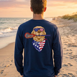 Person wearing a blue long-sleeve shirt with a dog graphic on a beach at sunset