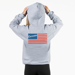 Person wearing a gray hoodie with a 'Lacrosse' and flag design on the back, against a white background.