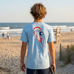 Person wearing a blue t-shirt with a graphic design on the beach