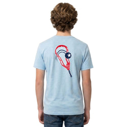 Person wearing a light blue t-shirt with a lacrosse head graphic design on the back, standing against a white background