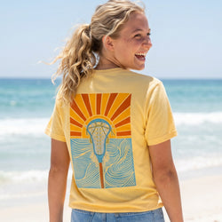 Girl wearing a yellow t-shirt with a lacrosse design on the beach
