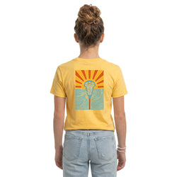 Person wearing a yellow t-shirt with a sunset lacrosse graphic design on the back, standing against a white background