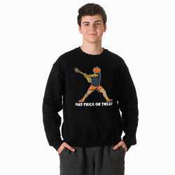 A young man wearing a black crewneck sweatshirt with a graphic of a lacrosse player with a pumpkin head and the text 'HAT-TRICK OR TREAT' underneath, paired with dark gray sweatpants against a plain white background.
