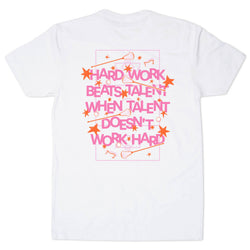 A white short-sleeve t-shirt with a graphic print on the front. The graphic features the motivational quote 'HARD WORK BEATS TALENT WHEN TALENT DOESN'T WORK HARD' in pink letters, surrounded by orange stars, lacrosse sticks, and a pink rectangular border.