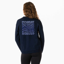 A woman viewed from behind wearing a navy blue sweatshirt with a large blue graphic print on the back that reads 'NO DAYS OFF' with crossed sticks. She is also wearing black leggings against a plain white studio background.