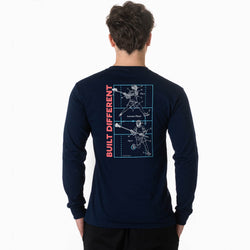 A man viewed from behind wearing a navy long-sleeve t-shirt with a large graphic on the back. The graphic features a vertical red text reading 'BUILT DIFFERENT' next to a blue blueprint-style diagram of lacrosse players.