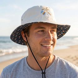 Man wearing a pickleball themed bucket hat on a beach