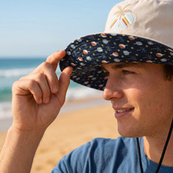Person wearing a patterned pickleball bucket hat on a beach