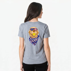 Person wearing a gray t-shirt with a patriotic pickleball dog graphic on the back, featuring an American flag bandana.