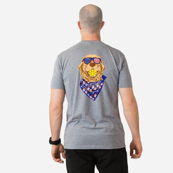 Person wearing a gray t-shirt with a patriotic graphic of a pickleball dog wearing sunglasses and a bandana on the back.