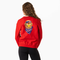Person wearing a red sweatshirt with a pickleball dog graphic design on the back, on a white background