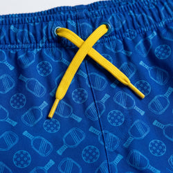 Blue shorts with pickleball pattern and yellow drawstring on a white background