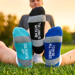 Person wearing socks with motivational phrases on grass