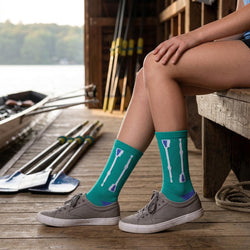 Person wearing teal socks with paddle design on a dock by a lake