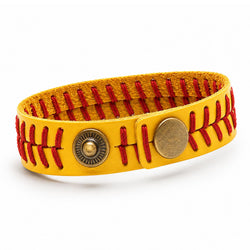 A yellow leather bracelet designed to look like a softball, featuring red stitched seams, a vintage-style brass button closure, and a round snap button, shown on a white background.
