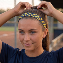 Person wearing a headband with yellow softballs on a sports field