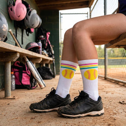 Person wearing socks with softball designs in a dugout.