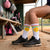 Person wearing socks with softball designs in a dugout.
