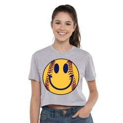 Person wearing a gray t-shirt with a smiley face softball design on a white background