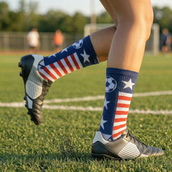 Person wearing patriotic-themed soccer socks on a grassy field