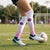 Person kicking a soccer ball on a field with polka dot socks