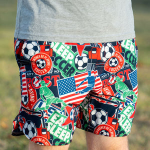 Colorful shorts with soccer-themed graphics and text on a grassy background