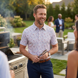 Man wearign a ptriotic themed polo shirt with a soccer patterned design at a cookout.