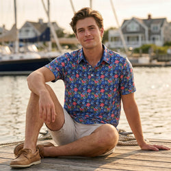 Teen wearing a soccer polo shirt sitting on a dock by a waterfront with boats and houses in the background