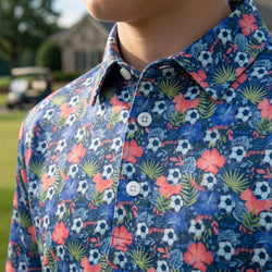 Close-up of a person wearing a colorful shirt with floral and soccer ball pattern.