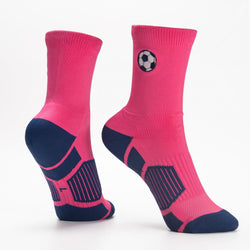 A pair of athletic crew socks in bright pink and navy blue, featuring a soccer ball graphic on the ankle and reinforced zones on the heel, sole, and toe.