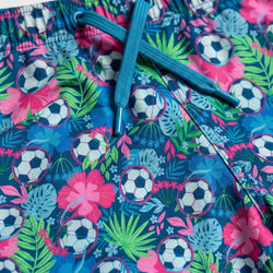 Colorful shorts with soccer ball and floral pattern on a blue background