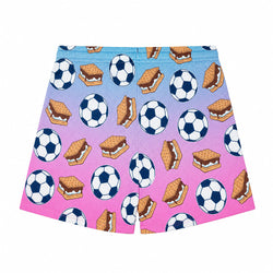 A pair of shorts featuring a colorful gradient background that transitions from light blue to purple to bright pink, covered in a playful pattern of soccer balls and graham cracker s'mores.