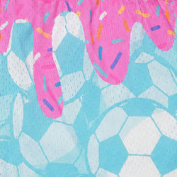 A close-up of a mesh fabric featuring a playful print of dripping pink frosting with colorful sprinkles over a light blue and white soccer ball pattern.