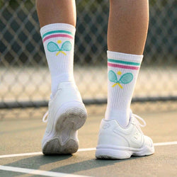 White sneakers and socks with tennis racket design on a tennis court
