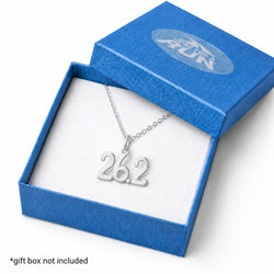 A silver necklace with a '26.2' runner silhouette pendant displayed inside an open blue gift box with a white insert.