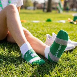 Person wearing green 'Lucky Socks' on grass