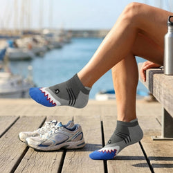 Person wearing shark-themed socks by a marina